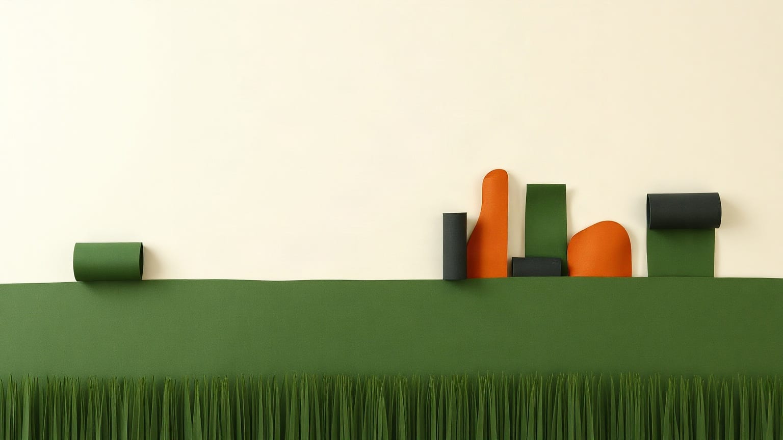 Upright abstract paper shapes in orange, green and charcoal standing on a band of green paper grass
